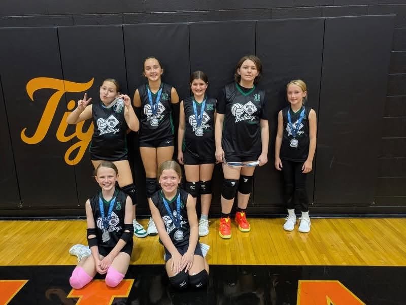BCRL volleyball team in black jerseys with medals